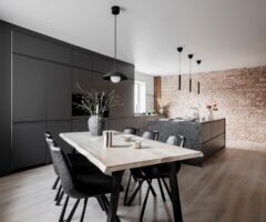 Una cucina total black e un muro in mattoni a vista per un appartamento minimal