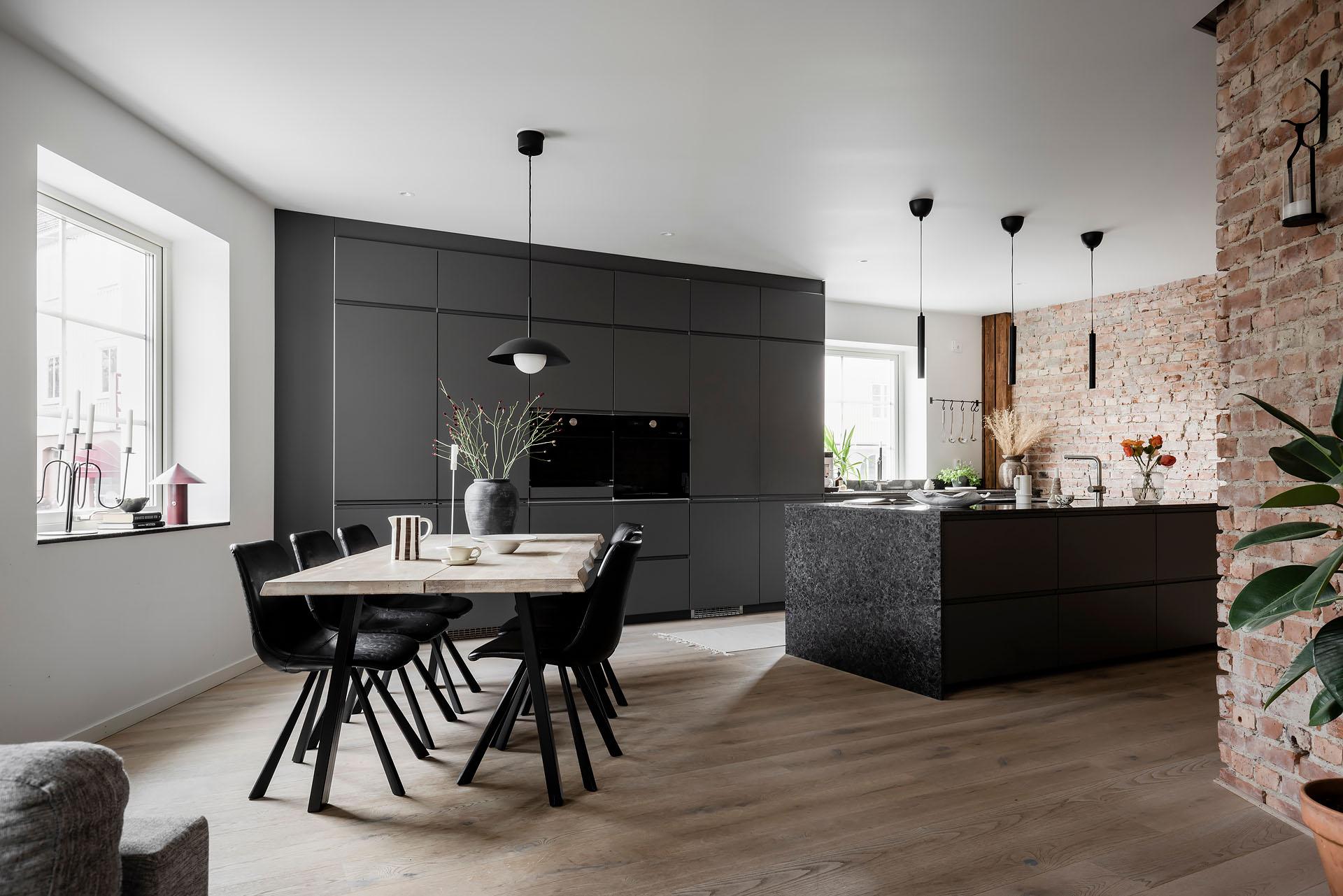 Cucina nera e parete in mattoni